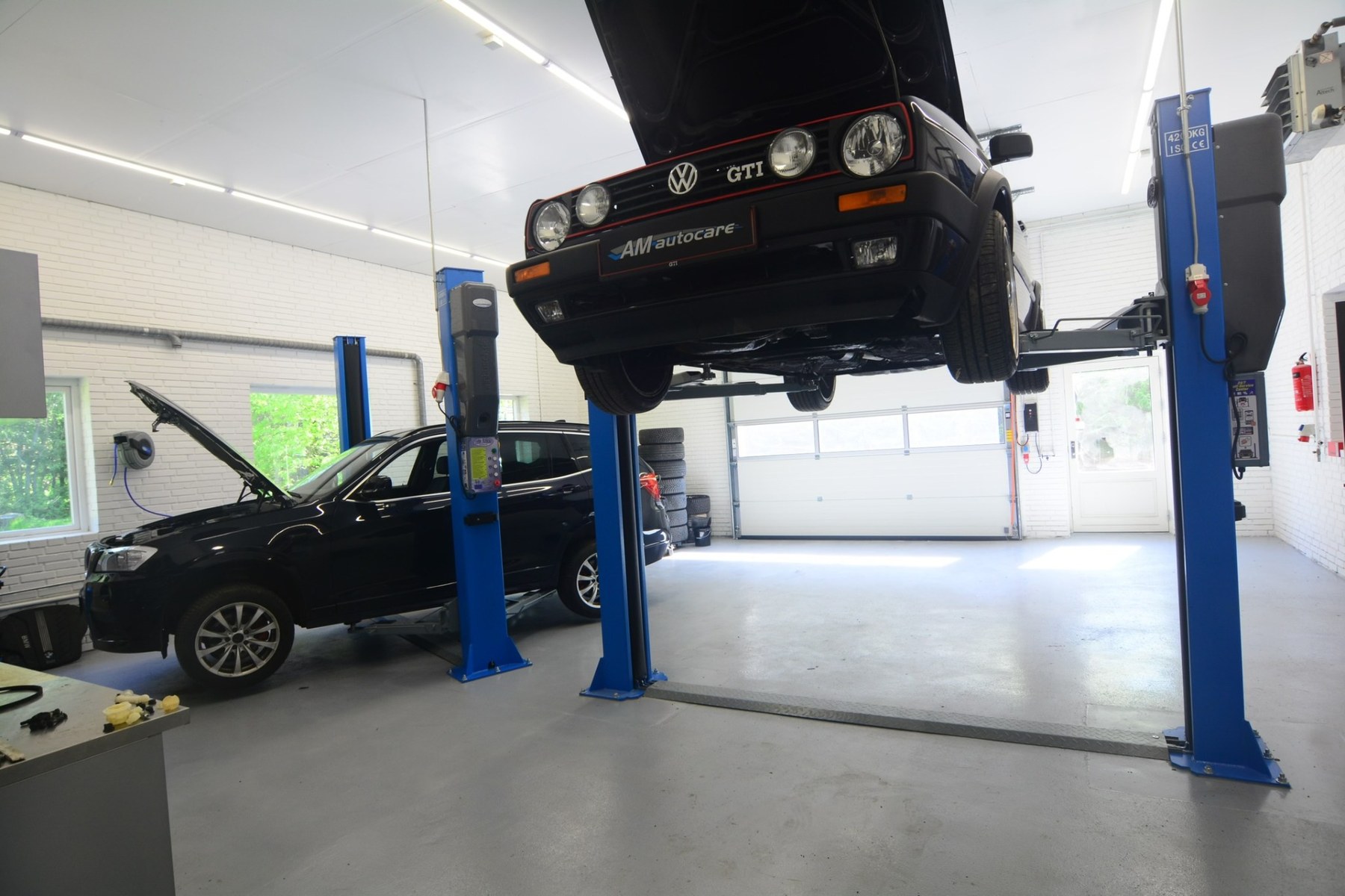 Bil på lift på AM Autocares værksted i Hinnerup